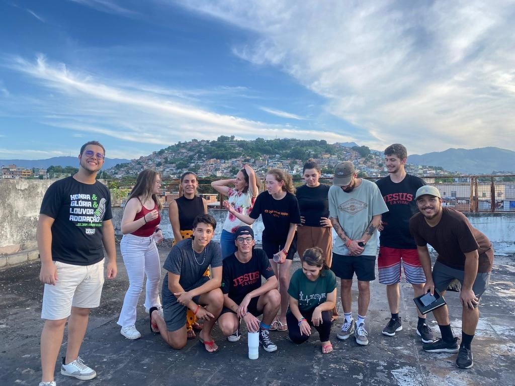 Grupo de missionários em uma laje, com o morro ao fundo
